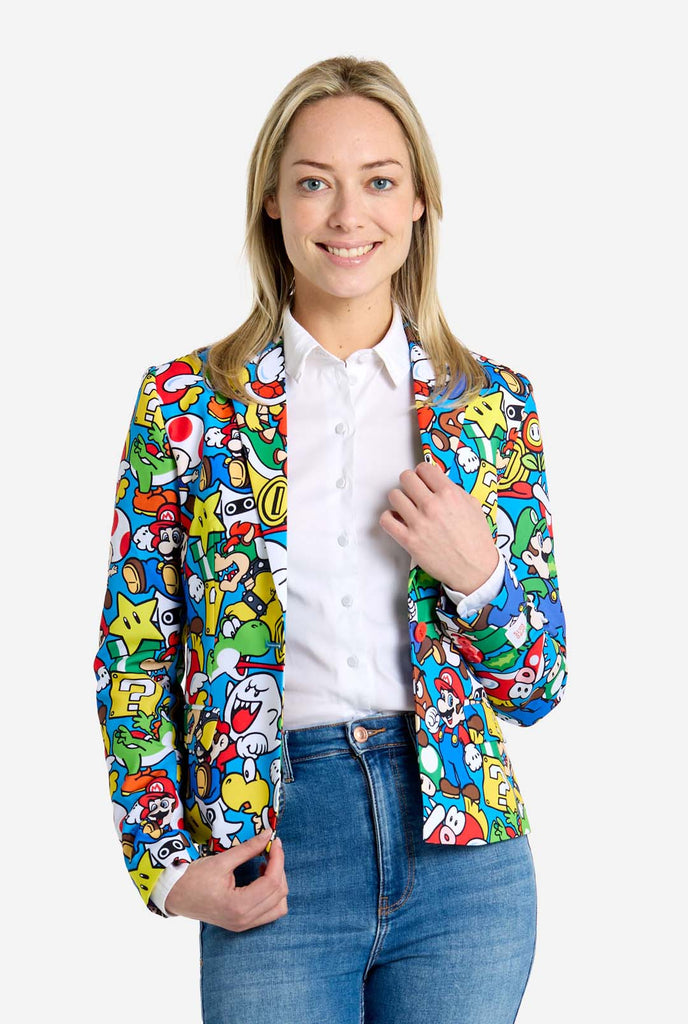 Vrouw draagt ​​een all-over print Super Mario blazer met iconische Super Mario karakters. De basis is lichtblauw, maar er is ook geel, rood en wit.