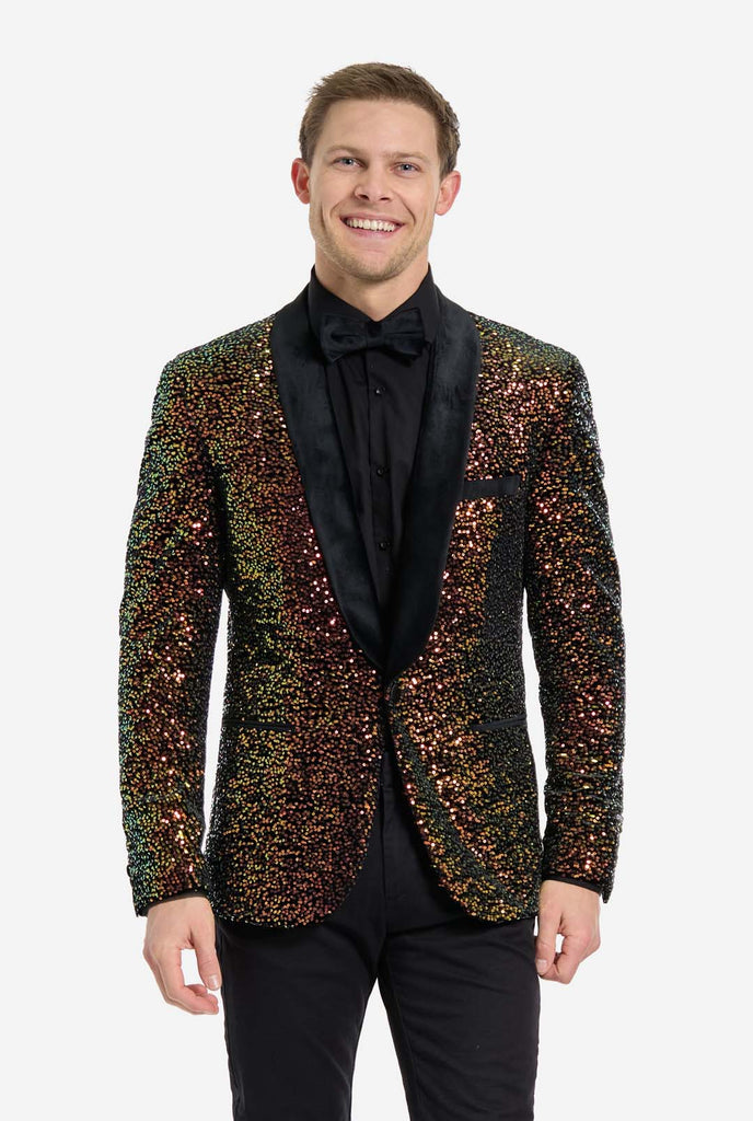 Man draagt ​​een blazer bedekt met glinsterende amberkleurige pailletten die het licht weerkaatsen in verschillende tinten goud, koper en groen.