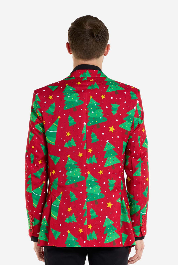 Man wearing red Christmas blazer for men with Christmas trees and stars print. Man also wearing a black pants and black men's shirt. View from the back.