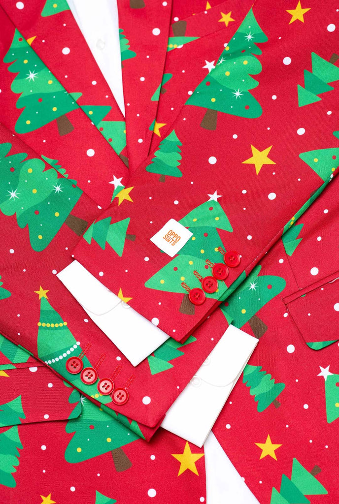 Man wearing red Christmas blazer for men with Christmas trees and stars print. Close up with white shirt.