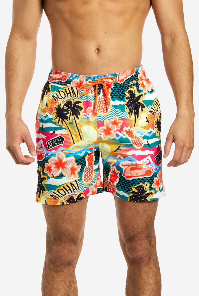 Man wearing swim trunks with tropical Hawaiian print, close up