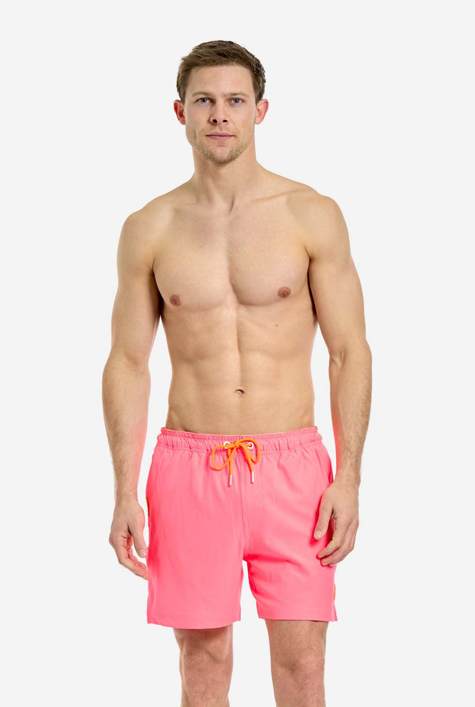 Man wearing Neon Pink Power swim trunks for men