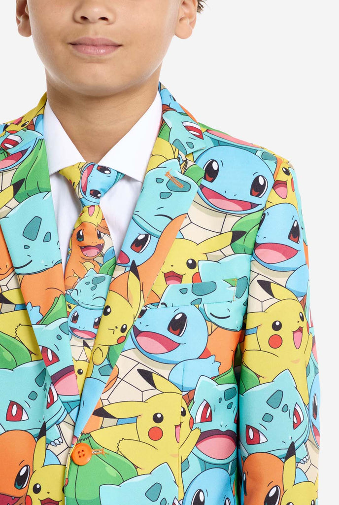 Tiener draagt ​​formeel multi-color pak met all-over Pokemon print. Het pak bevat de personages Pikachu, Bulbasaur, Charmander en Squirtle.