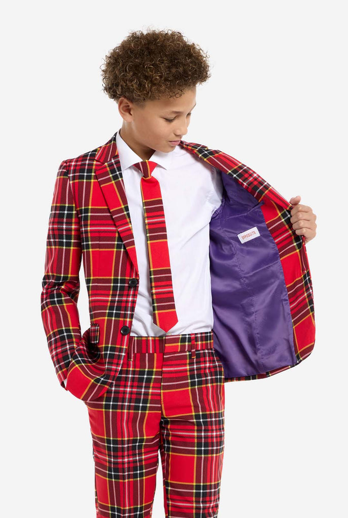 Tiener met een rood tartan kerstpak