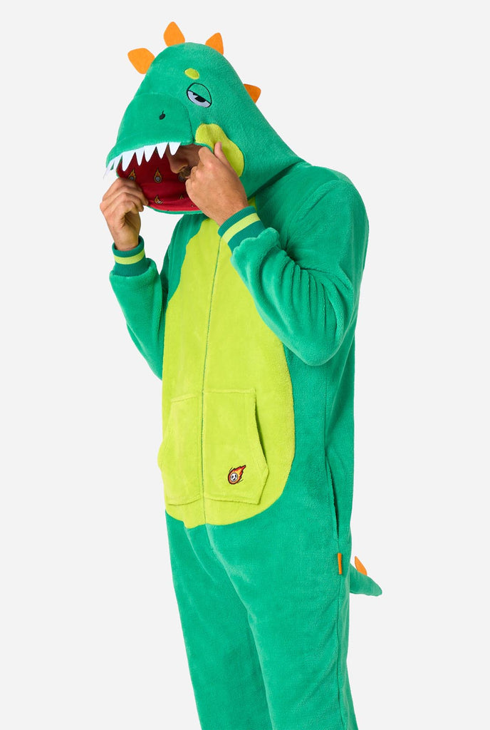 Een man draagt een groene dino onesie, onderdeel van de OppoSuits dieren onesie collectie.