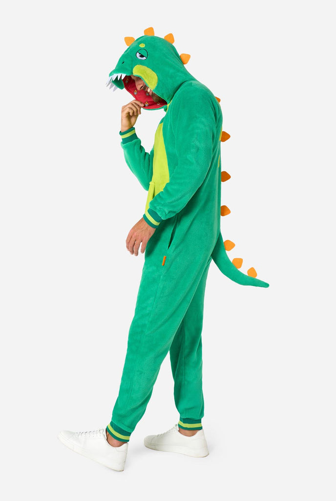 Een man draagt een groene dino onesie, onderdeel van de OppoSuits dieren onesie collectie.