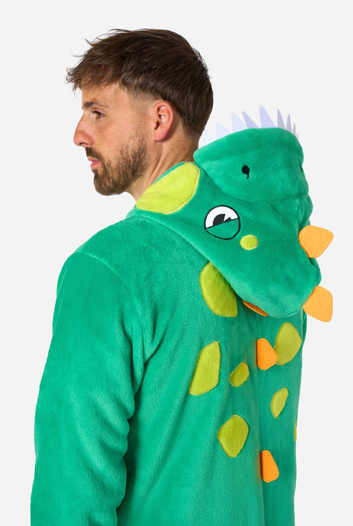 Een man draagt een groene dino onesie, onderdeel van de OppoSuits dieren onesie collectie.