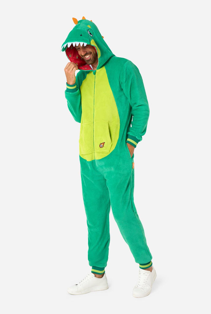 Een man draagt een groene dino onesie, onderdeel van de OppoSuits dieren onesie collectie.