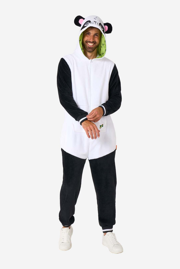 Een man draagt een zwart met witte panda onesie, onderdeel van de OppoSuits dieren onesie collectie.