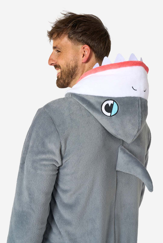 Een man draagt een grijs met witte haaien onesie, onderdeel van de OppoSuits dieren onesie collectie.