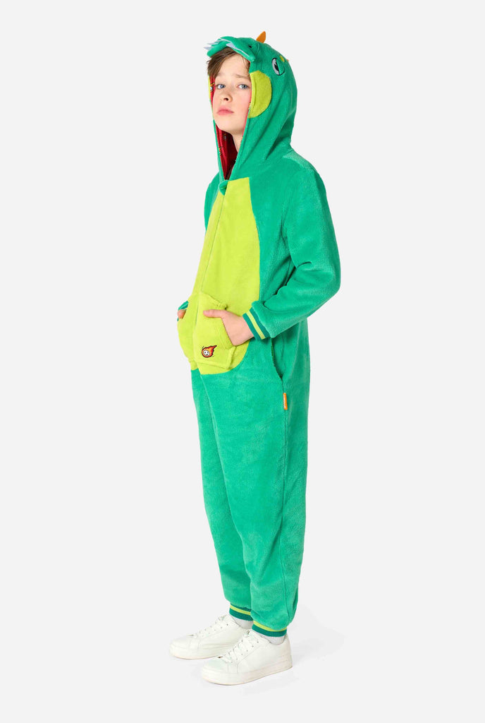 Kind draagt een groene dino onesie voor kinderen. Volledige foto.