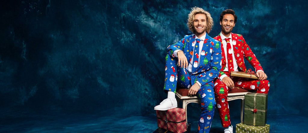 Twee mannen op een bankje met een OppoSuits Kerst pak aan. Een Rood pak en een Blauw pak.