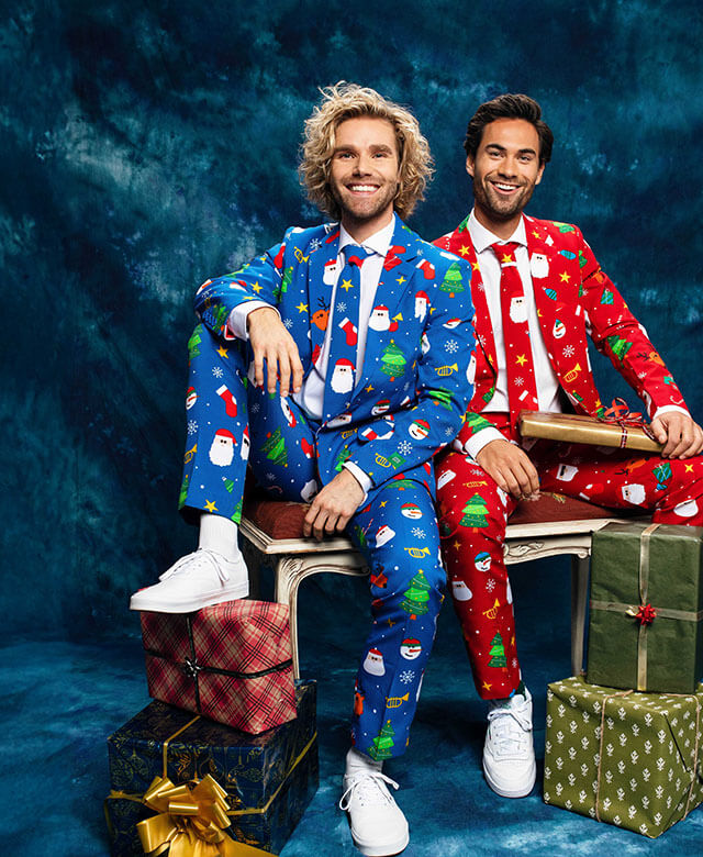 Twee mannen op een bankje met een OppoSuits Kerst pak aan. Een Rood pak en een Blauw pak.