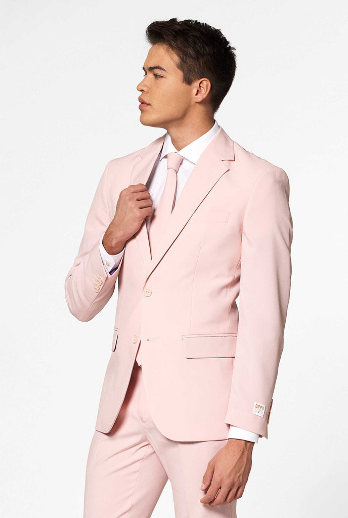 Man draagt OppoSuits Lush Blush zacht roze herenpak.