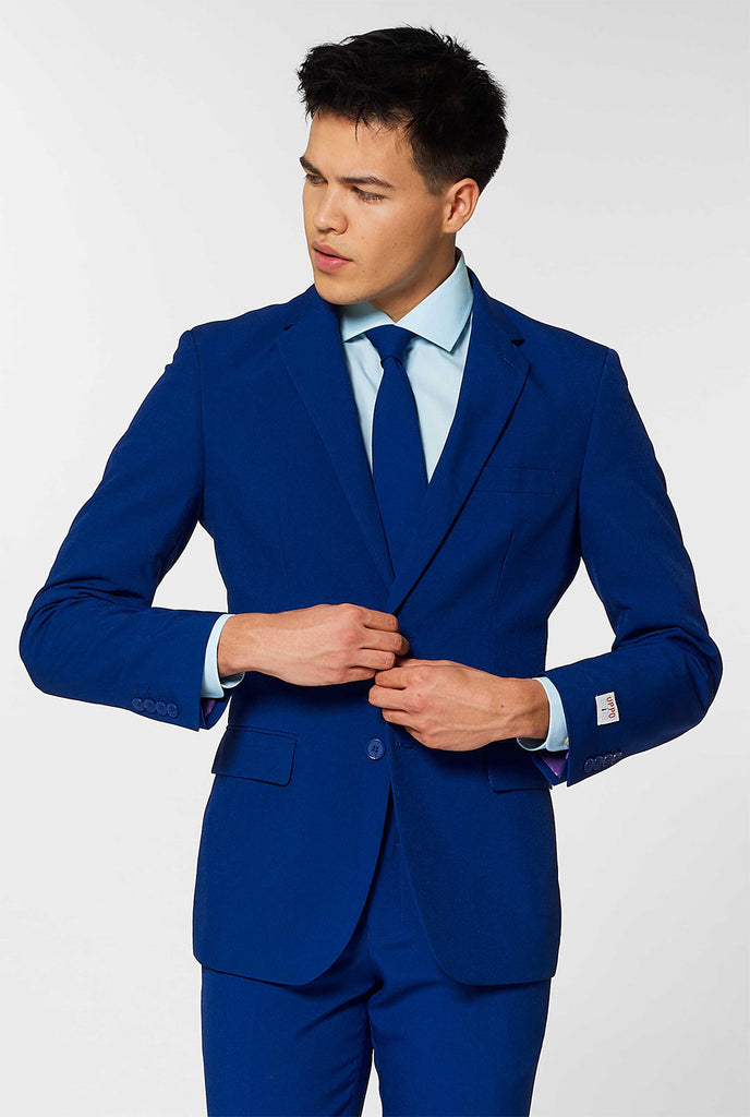 Man draagt OppoSuits Navy Royale donker blauw herenpak.